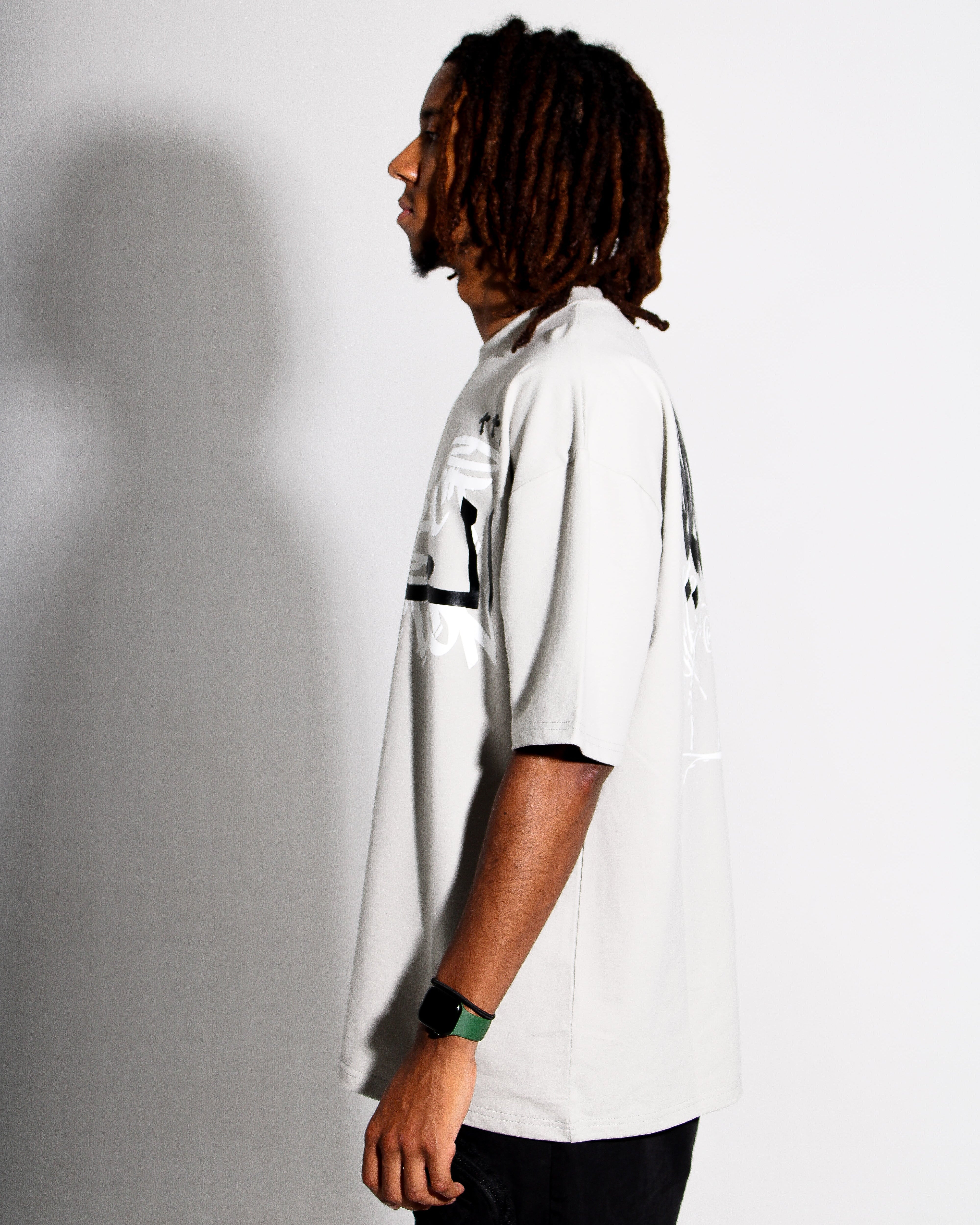 Person wearing a grey shirt with black accents against a plain background