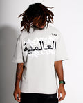 Person wearing a grey t-shirt with Arabic text on a plain background