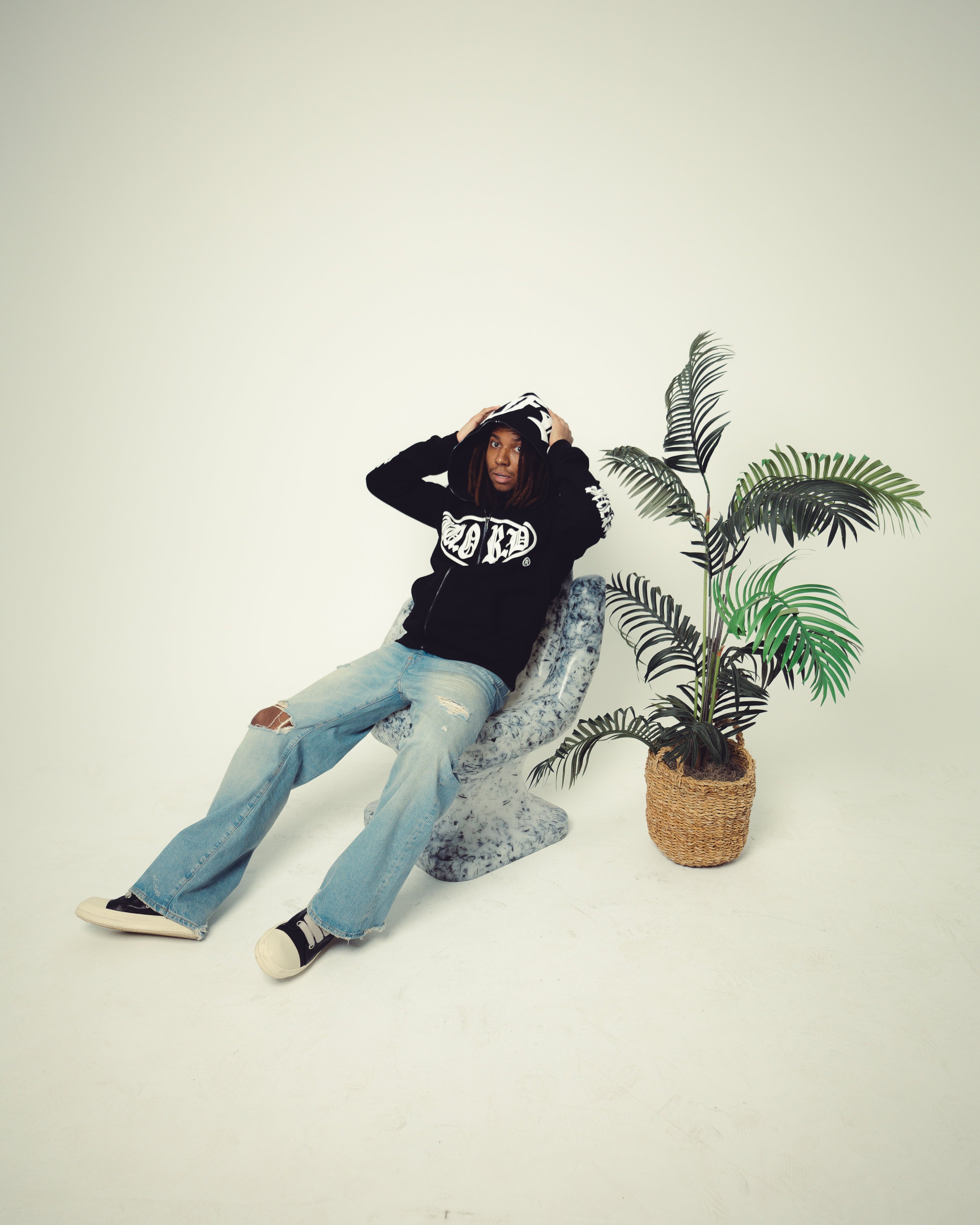 Person sitting on a chair with a plant in the background