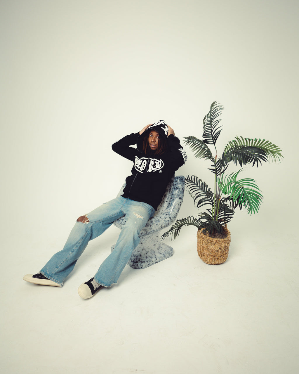 Person sitting on a chair with a plant in the background