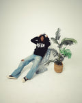 Person sitting on a chair with a plant in the background