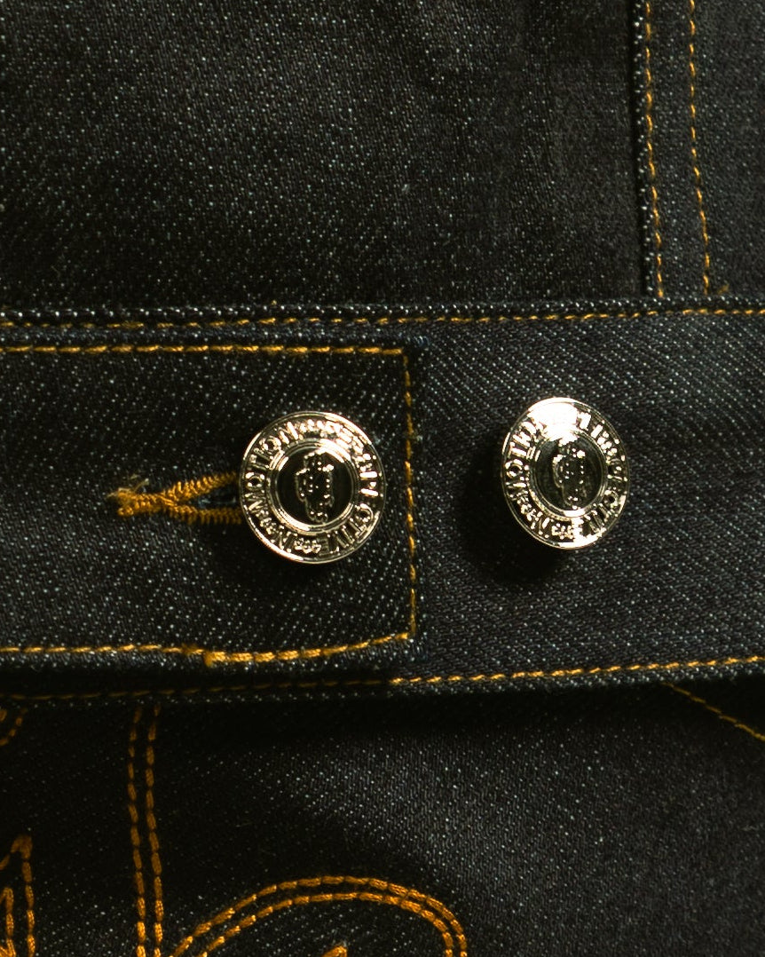 Black denim jacket with gold embroidery on a plain background
