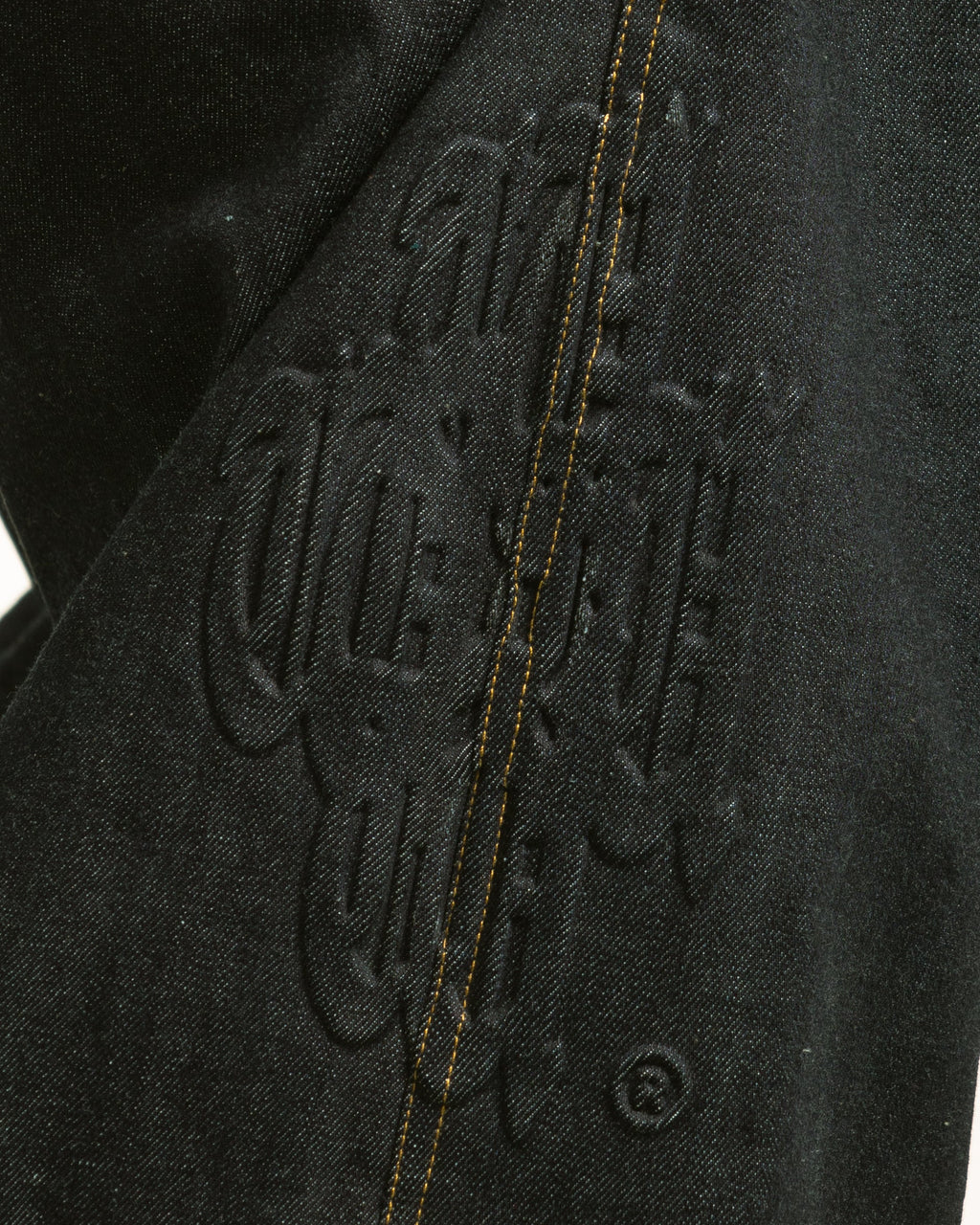 Close-up of a black jacket with branding on a white background
