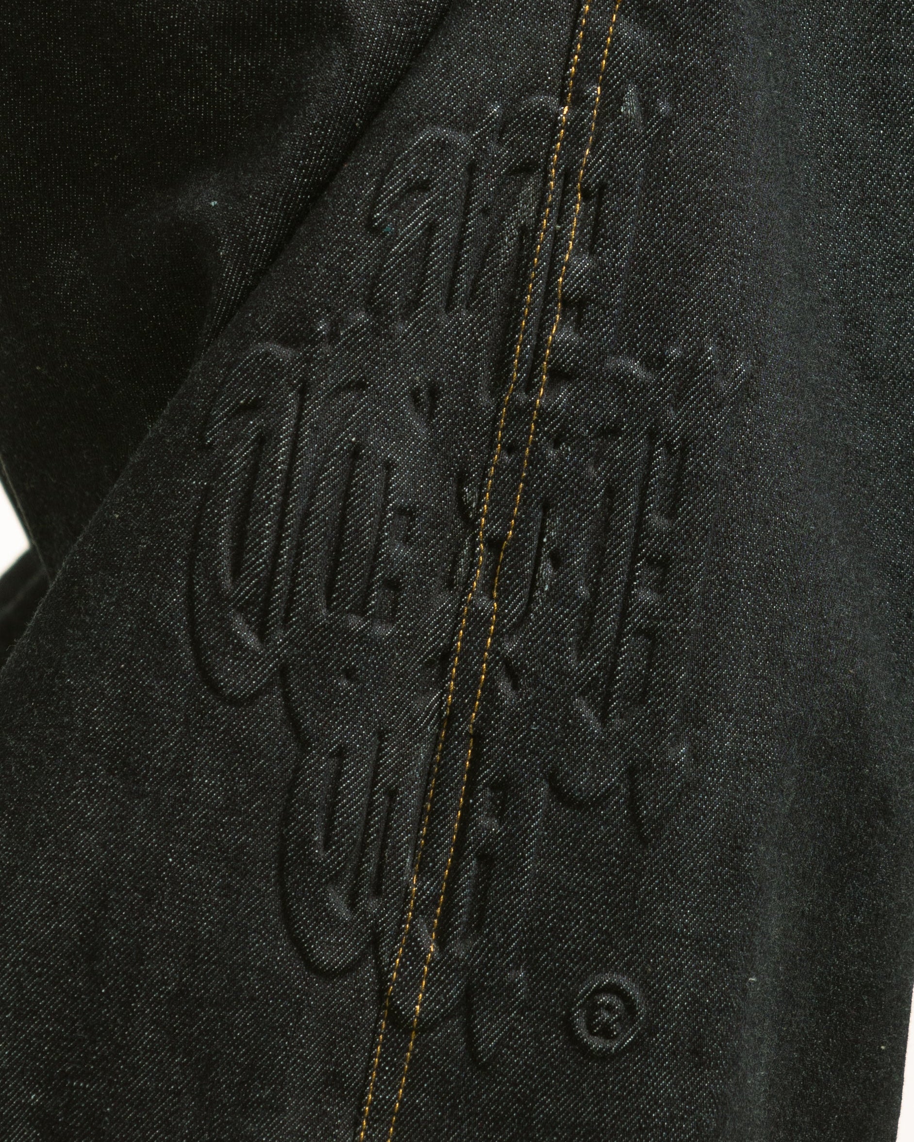 Close-up of a black jacket with branding on a white background